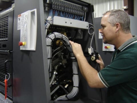 Technician servicing an offset press